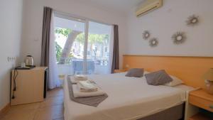 a bedroom with a bed and a large window at Mimosa Pension in Kaş