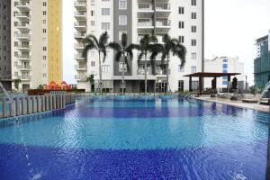 a large blue swimming pool in front of buildings at OnThree20 Araliya Apartment Colombo in Colombo