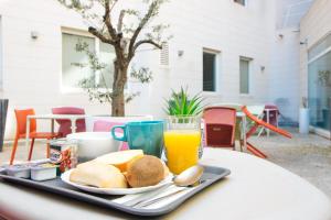 a tray of breakfast food and orange juice on a table at Twenty Business Flats Marseille Timone in Marseille