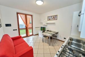 een woonkamer met een rode bank en een keuken bij Affittimoderni Bergamo Curno - CUMA8 in Curno