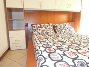 1 dormitorio con 1 cama con edredón blanco y negro en Affittimoderni Bergamo Curno - CUMA8, en Curno