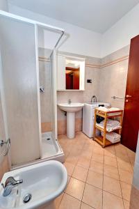 een badkamer met een wastafel, een bad en een wastafel bij Affittimoderni Bergamo Curno - CUMA8 in Curno