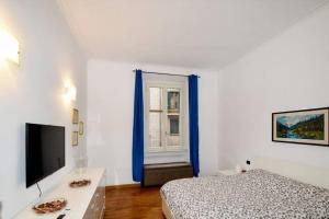 um quarto com uma cama, uma televisão e uma janela em Trilocale Centrale - Buenos Vibes em Milão