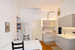 uma cozinha com armários brancos e uma mesa branca em Trilocale Centrale - Buenos Vibes em Milão