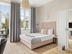 索波特Boho Rooms Sopot的一间带床和窗户的白色卧室