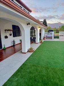 a house with a green lawn in the yard at Elvira Casa Vacanze in Iglesias