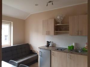 a kitchen with a couch and a kitchen with a sink at Rowy Vasco da Gama in Rowy