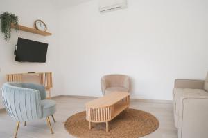 ein Wohnzimmer mit 2 Stühlen und einem Couchtisch in der Unterkunft VILLA BELLA in L'Ampolla