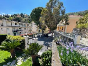 Blick auf einen Garten mit Blumen und Gebäuden in der Unterkunft Holiday Rooms La Campagnetta in Alassio