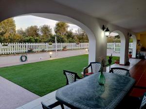 een patio met een tafel en stoelen en een gazon bij Elvira Casa Vacanze in Iglesias