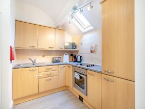 a kitchen with wooden cabinets and a stove top oven at Three - Uk43701 in Saint Annes on the Sea