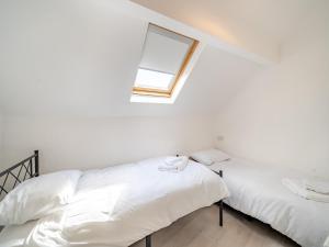 two beds in a white room with a window at Three - Uk43701 in Saint Annes on the Sea