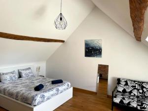 een witte slaapkamer met een bed en een stoel bij Cottage entier : 6 à 8 personnes - La Ferme du Try in Frasnes-lez-Gosselies