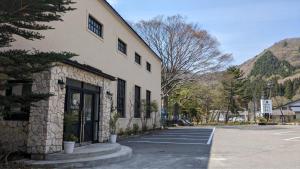 a building with a parking lot in front of it at Roots inawashiro Lake Area in Sekiwaki
