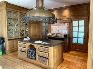 una cocina con una isla con una gran lámpara de araña en Cottage entier : 6 à 8 personnes - La Ferme du Try, en Frasnes-lez-Gosselies