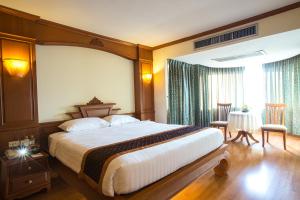 a hotel room with a large bed and a window at Furama Chiang Mai in Chiang Mai