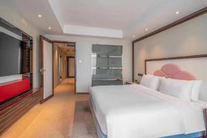 Postel nebo postele na pokoji v ubytování Suning Universal Hotel ALL-SUITES
