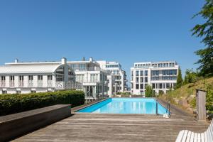 uma piscina com edifícios ao fundo em Villa Paula Strandperle em Ostseebad Sellin