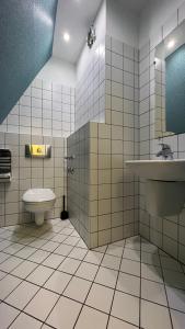 ein Bad mit einem WC und einem Waschbecken in der Unterkunft #5 SLADKIY SLIVA Maisonette Boutique Apartment in Leipzig