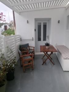 un patio con 2 sillas, una mesa y un banco en Santorita Suites en Akrotiri