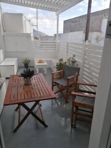 a patio with a wooden table and two chairs at Santorita Suites in Akrotiri