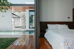 a bedroom with a bed and a glass wall at H1 Pool Villa in Chiang Mai