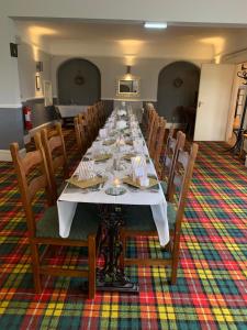 a long dining room with a long table and chairs at Navaar House Hotel in Penicuik