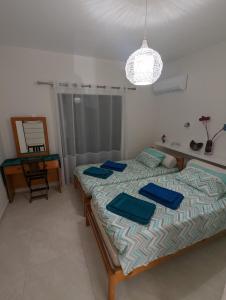 Un dormitorio con una cama con toallas azules. en DreamIsland Maisonette Protaras, en Paralimni