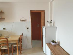 een keuken met een tafel en een witte koelkast bij Jozi Kaiser Apartment 3 in Durrës
