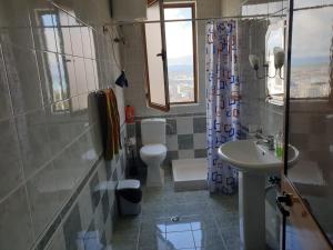 een badkamer met een wastafel, een toilet en een douche bij Jozi Kaiser Apartment 3 in Durrës