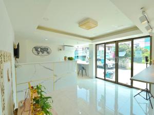 a kitchen with white walls and white floors and windows at RoomQuest Suvarnabhumi Ladkrabang 42 in Bangkok