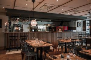 un restaurant avec des tables et des chaises en bois ainsi qu'un bar dans l'établissement Best Western Hotell Kramm, à Kramfors