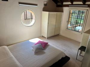 - une chambre avec un lit doté d'un oreiller rose dans l'établissement Borgo Storico Il Casetto, à Sasso Marconi
