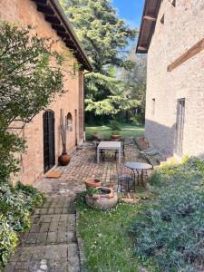 a patio with a table and chairs in a yard at Borgo Storico Il Casetto in Sasso Marconi