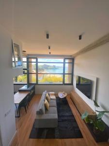 een woonkamer met een bank en een groot raam bij Nomads Hosting Alojamientos in Oleiros
