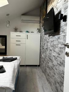 a bedroom with a bed and a tv on a brick wall at MG Mamaia North Villa in Mamaia Nord