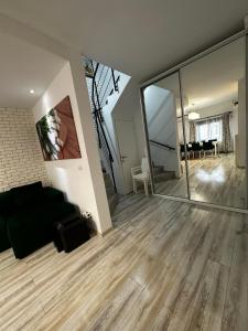 a living room with a black couch and a large mirror at MG Mamaia North Villa in Mamaia Sat/Năvodari