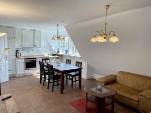 uma cozinha e sala de estar com uma mesa e um sofá em Min Hüs OG em Westerland