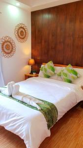 a bedroom with a large white bed with a wooden headboard at The Farm Shack Casitas in Amadeo