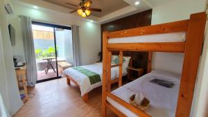 a bedroom with two bunk beds and a balcony at The Farm Shack Casitas in Amadeo