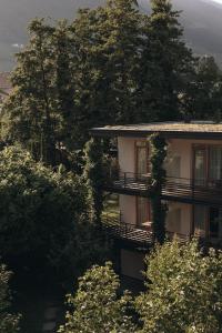 ein Gebäude mit Bäumen davor in der Unterkunft Hotel Schwarzschmied, a Member of Design Hotels in Lana