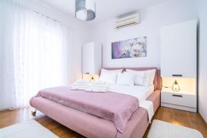 Apartment & Rooms Duja في زاتون: غرفة نوم مع سرير كبير مع مسند وردي