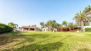 a large yard with houses and palm trees at Luxury Villa Maspalomas Golf in Maspalomas