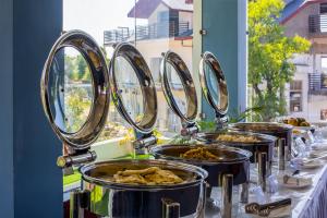 una fila de bandejas de comida sobre una mesa en Treebo Ortus Residency, en Dharamshala