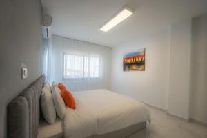 a white bedroom with a bed and a couch at Al Kawther Hotel Apartments in Amman