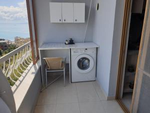 a balcony with a washing machine and a table at Jozi Kaiser Apartment 3 in Durrës