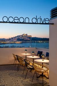 a group of tables and chairs on a balcony at Ocean Drive Ibiza in Ibiza Town