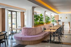 un restaurante con un sofá púrpura, mesas y sillas en Ocean Drive Ibiza en Ibiza