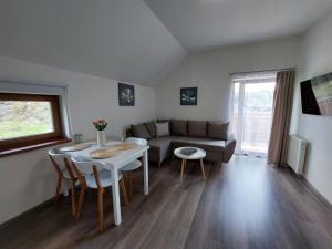 ein Wohnzimmer mit einem Tisch und einem Sofa in der Unterkunft Rezidence GreenHill ⃰ ⃰ ⃰ in Kraslice