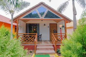 a cottage with a front door with a porch at Natures Dreamland Holiday Homes, Igatpuri in Igatpuri